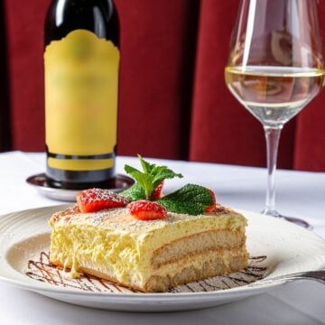 Tiramisu dessert with a bottle and glass of white wine at Rosebud Steakhouse